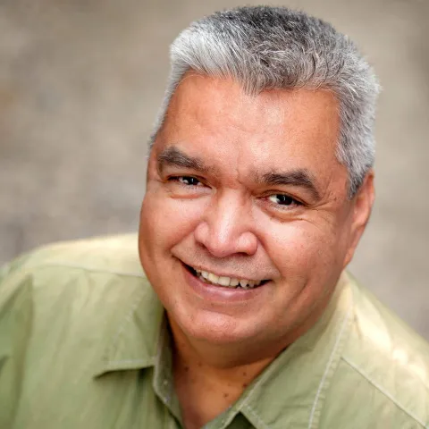 Russell wearing a green shirt and smiling looking up at the camera