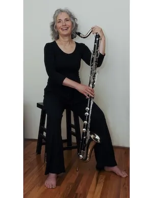 Johanna sitting and smiling with her bass clarinet