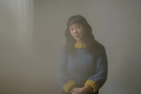 Robyn Jacob in a blue sweater with a yellow collar and sleeves